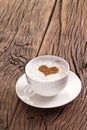 Cup of cappuccino with ground cinnamon in the form of heart.