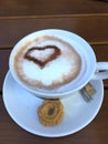 Cup cappuccino with a heart of cocoa decorated milk foam