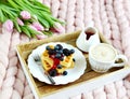 Cup with cappuccino and homemade Belgian waffles with strawberry sauce and berries, pink pastel giant blanket