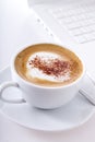 Cup of cappuccino with laptop