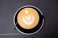 Cup of cappuccino with latte art. Coffee in black cup on dark table in cafe. Food banner Royalty Free Stock Photo