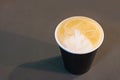 Cup of cappuccino with a pattern on the foam on gray background