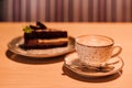 A cup of cappuccino and a piece of cake on the table in the restaurant