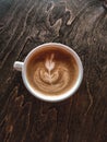 A cup of cappuccino on a table in a cafe. Beautiful plant drawing Leaf on Latte coffee froth. View from above. Flat lay. Delicious Royalty Free Stock Photo