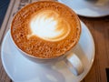 A cup of cappuccino on a table in a cafe. Drawing Heart on Latte coffee froth. View from above. Delicious coffee for Royalty Free Stock Photo