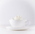 Cup of cappuccino with cream on white background