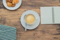 a cup of cappuccino on wooden table and notebook