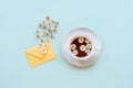 A cup of chamomile tea, an envelope and daisy flowers on blue background. Top view, flat lay, copy space Royalty Free Stock Photo