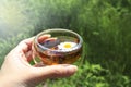 Cup of chamomile tea on a grey stone background with two wooden hearts and a bouquet of chamomiles Royalty Free Stock Photo