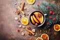 Cup of christmas mulled wine or gluhwein with spices and orange slices on rustic table top view. Traditional drink on winter.