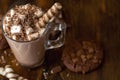 Cup of cocoa with marshmallows and chocolate chip cookies on dark wooden background