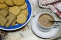 A cup of cocoa milk next to a plate of assorted cookies Royalty Free Stock Photo