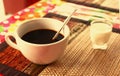 Cup of cofe and cream on bamboo mat Royalty Free Stock Photo