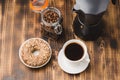 Cup of cofee with cofee beans and black maker. Top view. Cup of black coffee in a cup, donut with nuts and grains in a glass jar Royalty Free Stock Photo