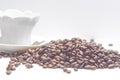 Cup of coffe alongside with coffe beans on white background