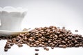 Cup of coffe alongside with coffe beans on white background