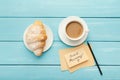 Cup of coffe and croissant on turquoise rustic table, top view Royalty Free Stock Photo