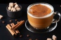 Cup of coffe with milk on a dark background. Hot latte or Cappuccino prepared with milk on a black wooden table