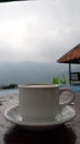 A cup of coffe ona table with a view of pool and mountain Royalty Free Stock Photo
