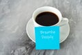 Cup of coffee and adhesive note with text Breath deeply Royalty Free Stock Photo
