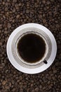 Cup of coffee against beans background closeup Royalty Free Stock Photo