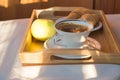 Cup of coffee, Apple on wooden plate closeup. Breakfast, Selective focus