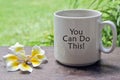 You can do this. Inspirational text message on a coffee cup with flower on the table.