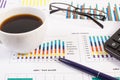 Cup of coffee, ballpen, computer keyboard and financial chart showing different production or sales statistics. Business Royalty Free Stock Photo