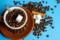 Cup of coffee with beans from above on blue background with cinnamon and sugar Royalty Free Stock Photo