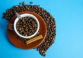 Cup of coffee with beans from above on blue background with cinnamon and sugar Royalty Free Stock Photo