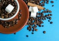 Cup of coffee with beans from above on blue background with cinnamon and sugar Royalty Free Stock Photo