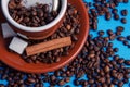 Cup of coffee with beans from above on blue background with cinnamon and sugar Royalty Free Stock Photo