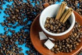 Cup of coffee with beans from above on blue background with cinnamon and sugar Royalty Free Stock Photo