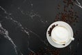 Cup of coffee with beans, with black marble background