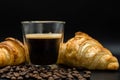 Cup of coffee with beans and croissants isolated on black background Royalty Free Stock Photo