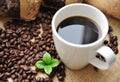 Cup of coffee with beans and leaf Royalty Free Stock Photo