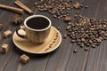 Cup of coffee, coffee beans sprinkled  on table. Spices star anise and pieces of brown sugar Royalty Free Stock Photo