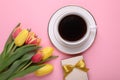 Cup of coffee, beautiful tulips and gift box on pink background, flat lay Royalty Free Stock Photo