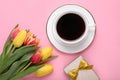 Cup of coffee, beautiful tulips and gift box on pink background, flat lay Royalty Free Stock Photo