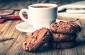 Cup of coffee with biscuit cookies and newspapper. Chocolate biscuit cookies. Chocolate cookies on white linen napkin on wooden ta Royalty Free Stock Photo