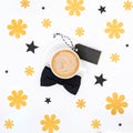 Cup of coffee and black bow tie on white background flat lay. Floral Fathers day still life setup. Royalty Free Stock Photo