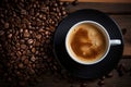 a cup of coffee on a black plate with coffee beans on a wooden table Royalty Free Stock Photo