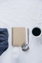 Cup coffee , blue knitted sweater, notebook with pen, clock, candle on bed, top view