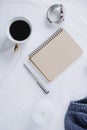 Cup coffee , blue knitted sweater, notebook with pen, clock, candle on bed, top view