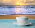 A cup of coffee with blurred beach sunset or sunrise and colorful of cloud sky in twilight Royalty Free Stock Photo