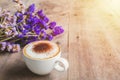 A cup of coffee with bouquet of violet dried flowers on wooden f Royalty Free Stock Photo