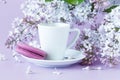 Cup of coffee and branches of blooming lilac