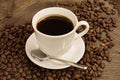 Cup of coffee with brown beans around. Royalty Free Stock Photo