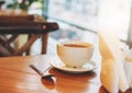 Cup of coffee on cafe wooden table against window in morning Royalty Free Stock Photo