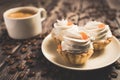 A cup of coffee and cake baskets with brown cream and berry.